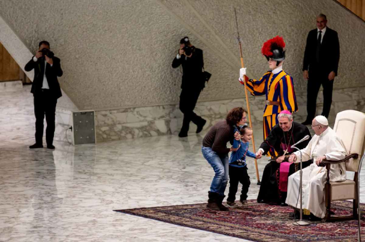 bambino sale sul palco durante l'udienza del Papa